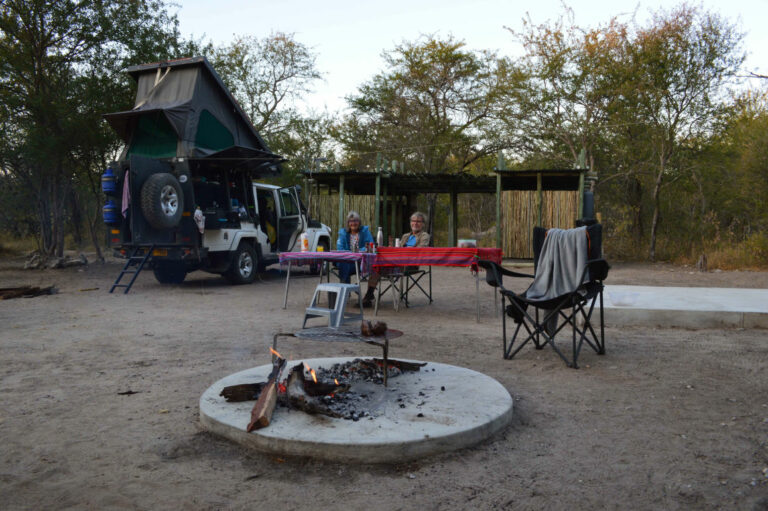 Khaudum camping – rooftop-tent campsite beside a fire ring