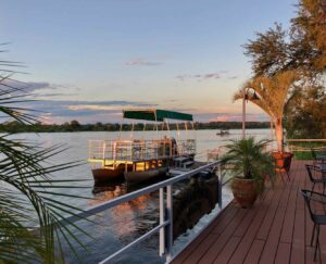 Okavango River lodge – safari boat moored beside the deck