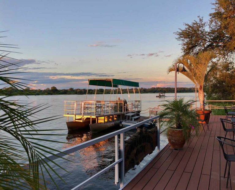 Okavango River lodge – safari boat moored beside the deck