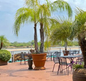 Nunda River Lodge – palm-framed terrace overlooking the river
