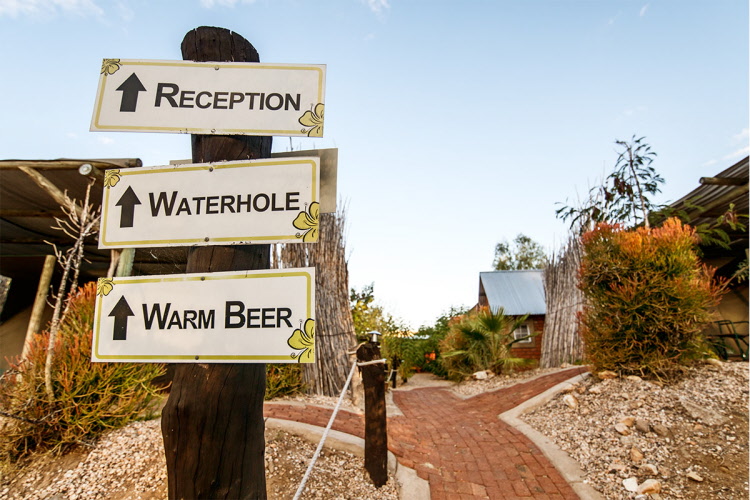 UrbanCamp Windhoek – wooden signposts to reception and bar