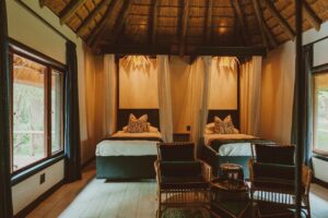 Twin-bed room with mosquito nets at Namushasha River Lodge