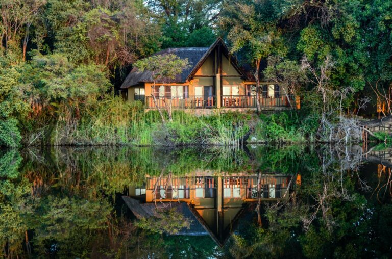 Namushasha River Lodge bungalow reflected in the Kwando River