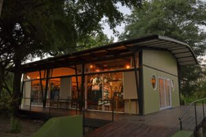 Main lodge building among riverside trees at Zambezi Mubala Lodge